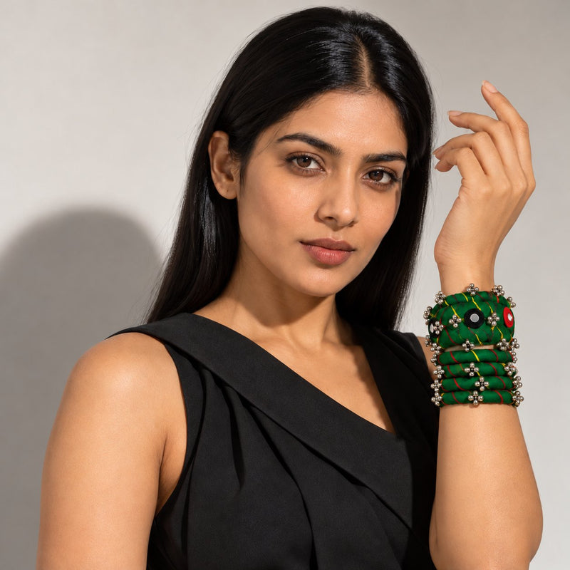 Green leheriya fabric bangles with ghungroo and mirror work stacked on a wrist