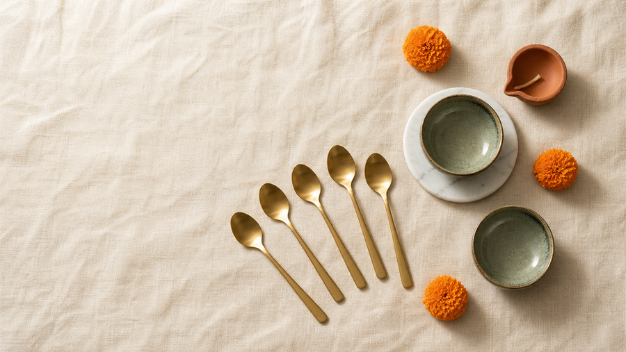 Handcrafted Diwali gifts from House of Falguni, with gold-tone dessert spoons and hand-glazed ceramic set out on a festive table