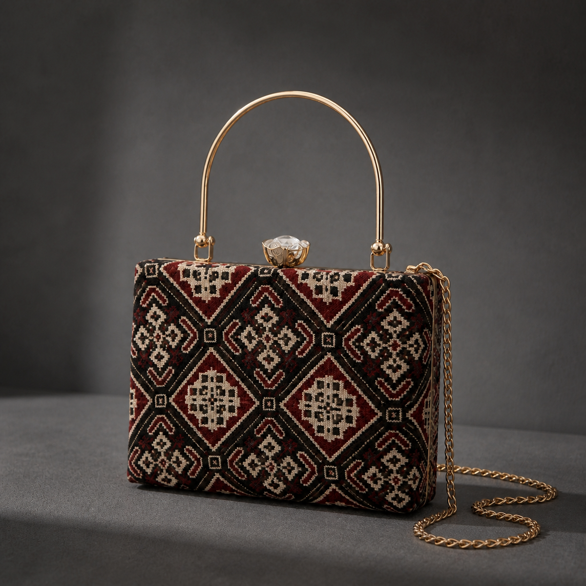 Ruhani maroon Ajrakh Mashru silk frame clutch with diamond medallions, gold-tone top handle and detachable chain