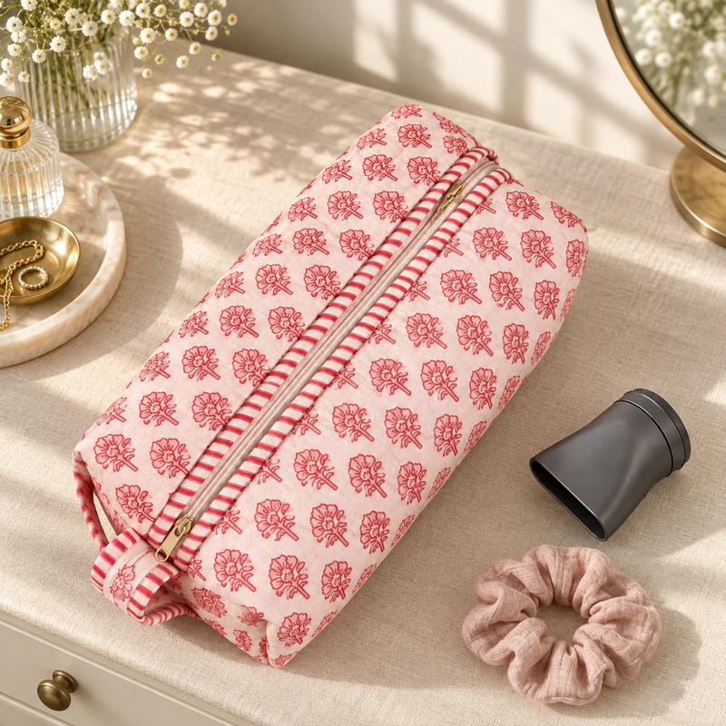 Gulaab quilted hair tool bag with small red floral print on a dressing table.