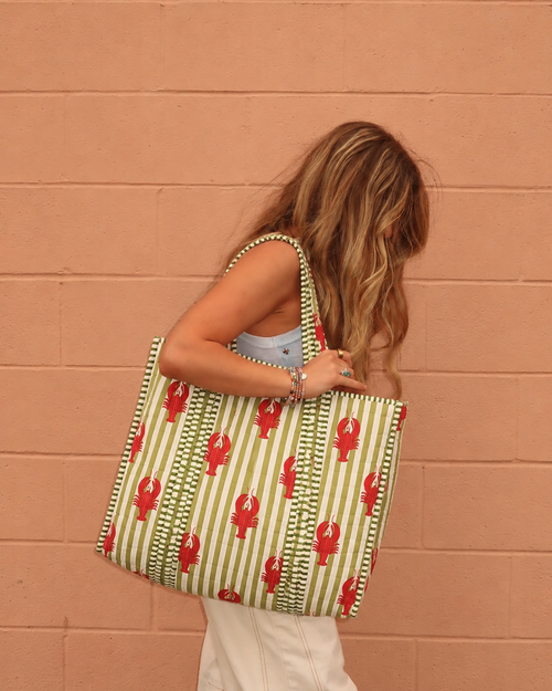 Aakar large quilted tote with red lobsters on olive and white stripes, carried on the shoulder