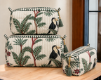 Angan pouch set stacked on a wooden table, showing the three sizes and tasselled zip pulls