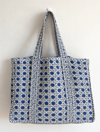 Samudra large quilted tote in a blue and white cane-weave print, hanging flat against a white wall