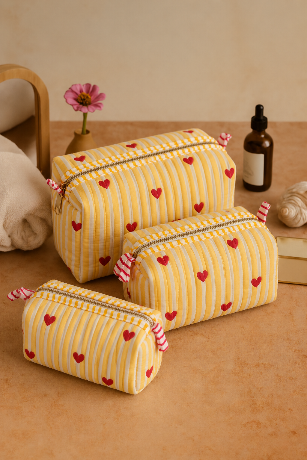 Sunehri yellow stripe and red heart pouches in three sizes, with pink-and-white striped zip pulls