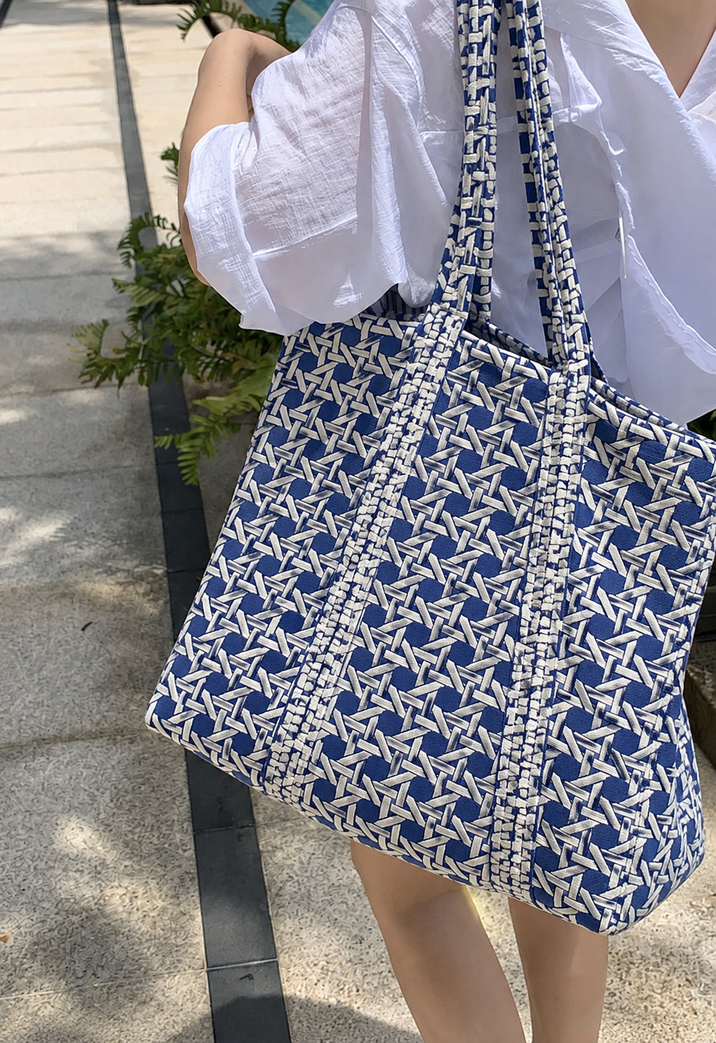 Samudra blue cane print quilted tote carried on the shoulder outdoors