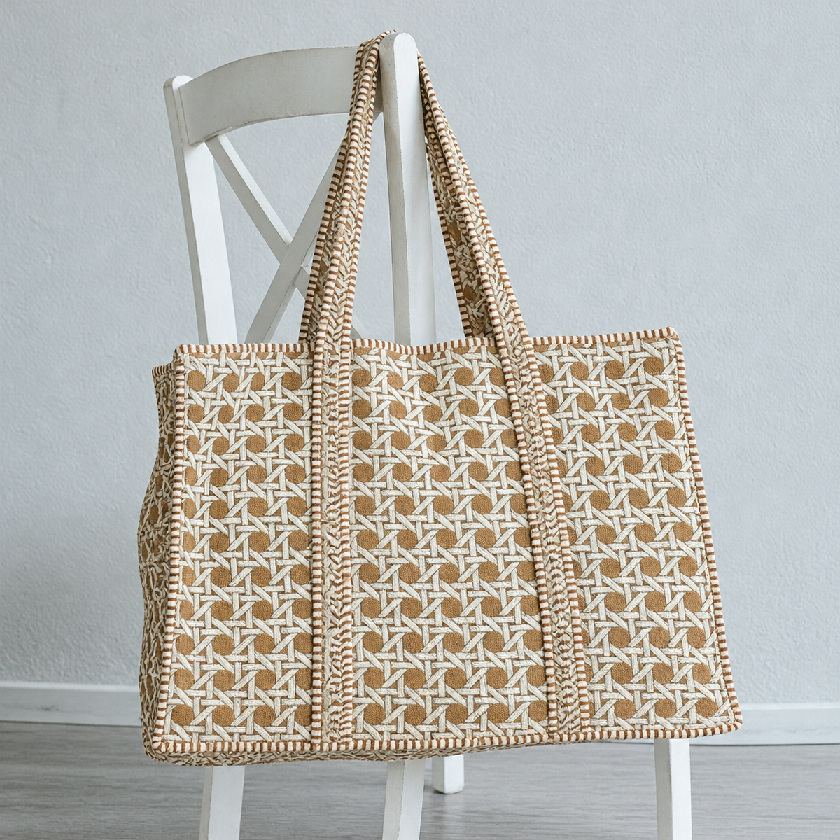 Mitti sand cane print quilted tote hanging on a white wooden chair