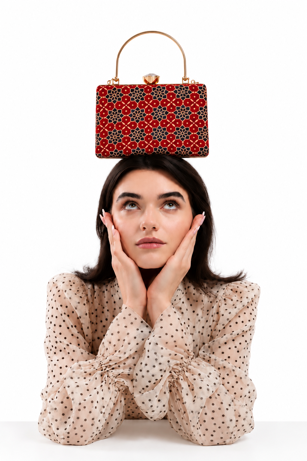 Laal Noor rectangular red Ajrakh Mashru silk handbag balanced on the head of a model in a polka-dot blouse