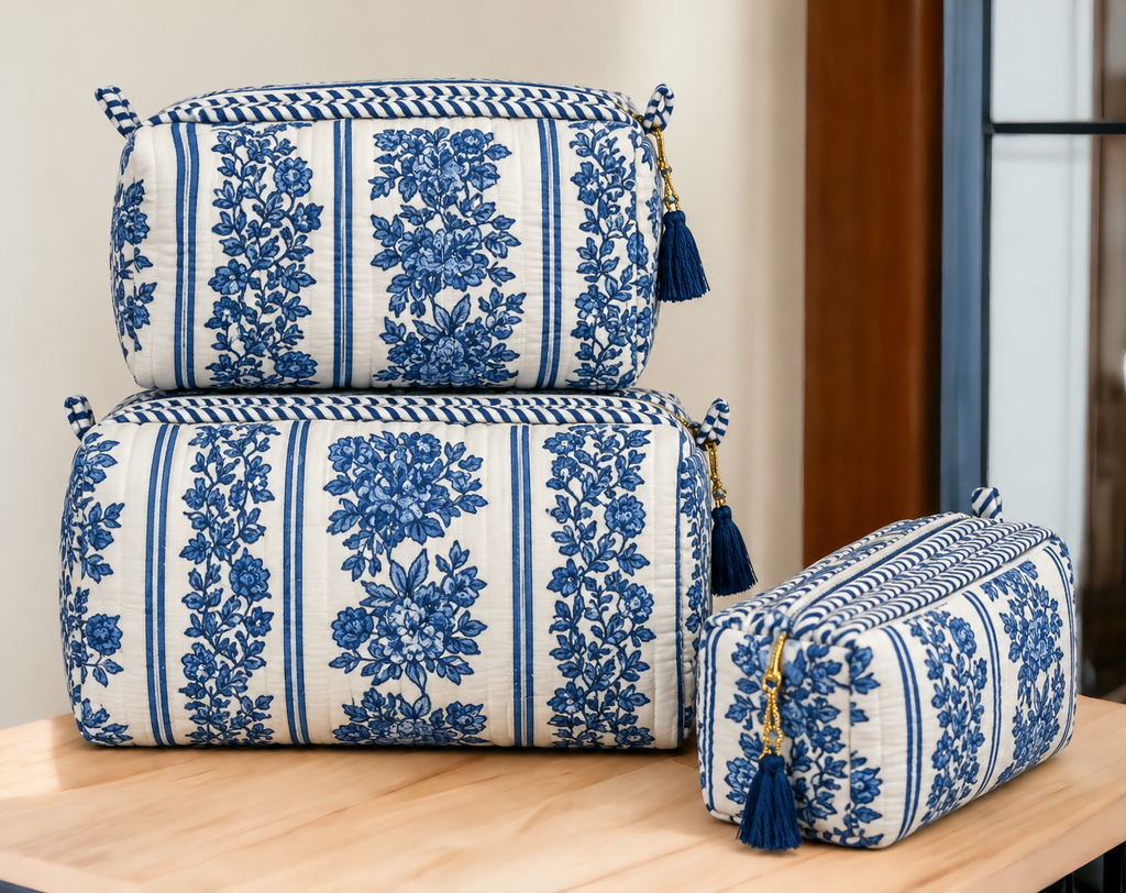 Jharna blue floral quilted pouches stacked, with blue tassels on the gold-tone zip pulls