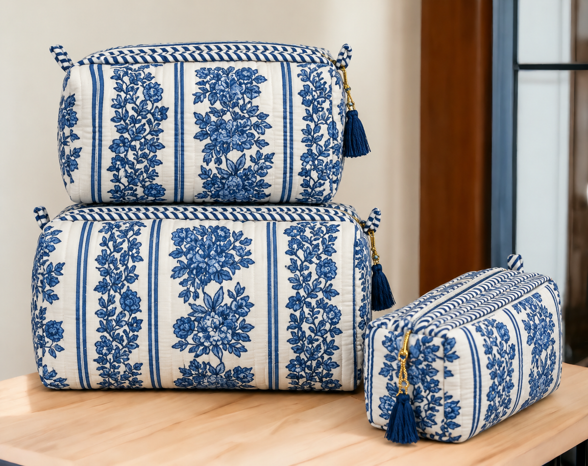 Jharna blue floral quilted pouches stacked, with blue tassels on the gold-tone zip pulls