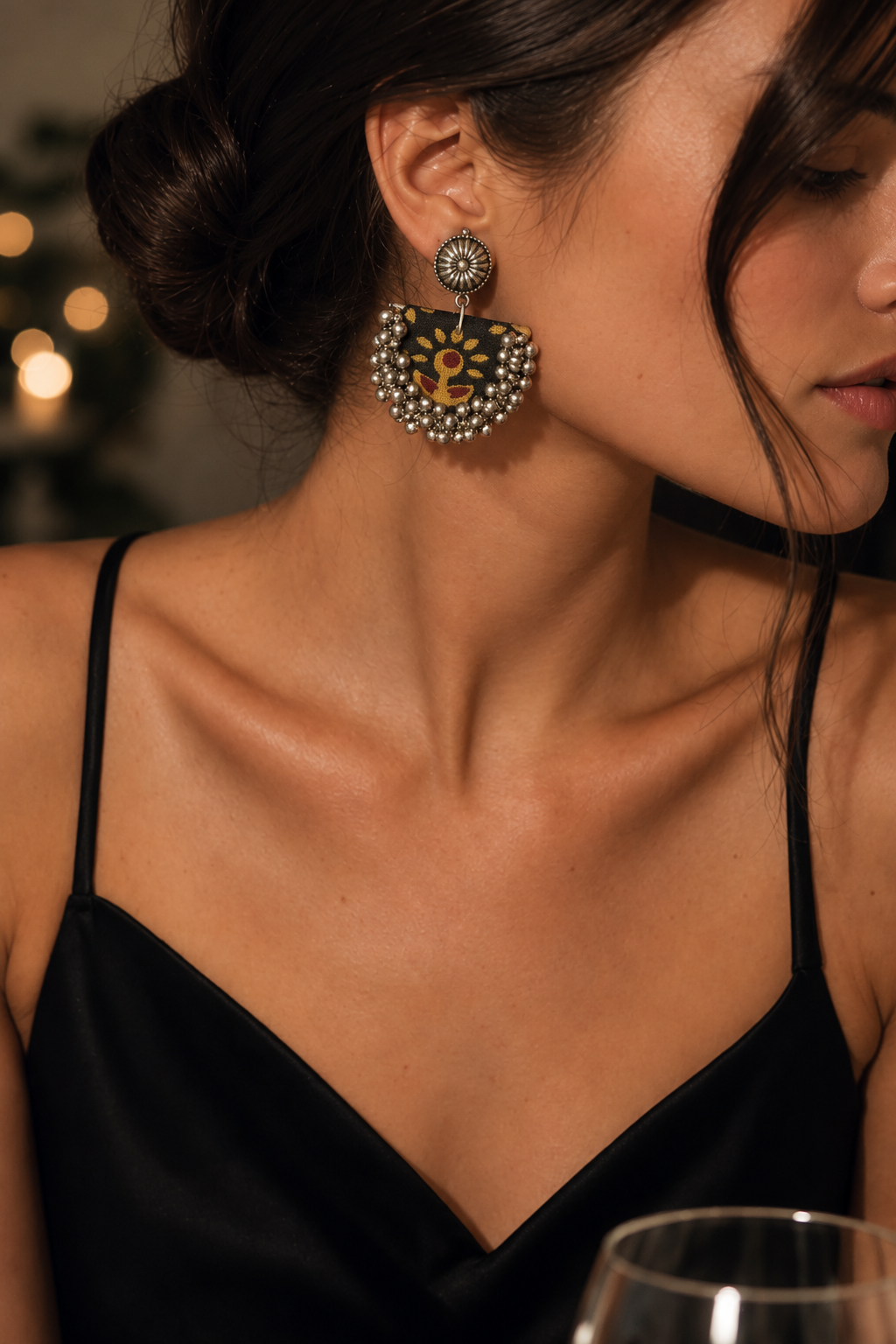 Black Chandbali Earrings with Ghungroo styled for evening with a black slip dress: black crescent printed with mustard flowers and a ghungroo fringe