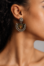 Close-up of a Black Chandbali Earring on the ear: kundan top over a black fabric crescent printed with mustard flowers, edged with ghungroo bells