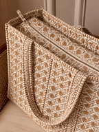 Mitti sand cane print quilted tote from above, showing the zip across the top and the striped binding