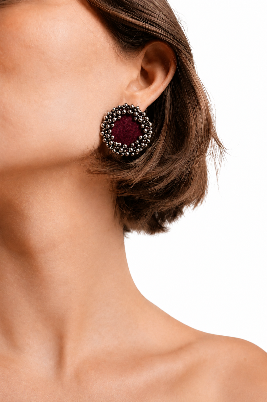 Maroon fabric ghungroo stud earring ringed with silver bells, worn on the ear