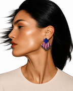 Blue and pink Geometric Ghungroo earrings: royal blue square stud over a pink-and-white striped fabric diamond edged with silver ghungroo bells, worn by a model