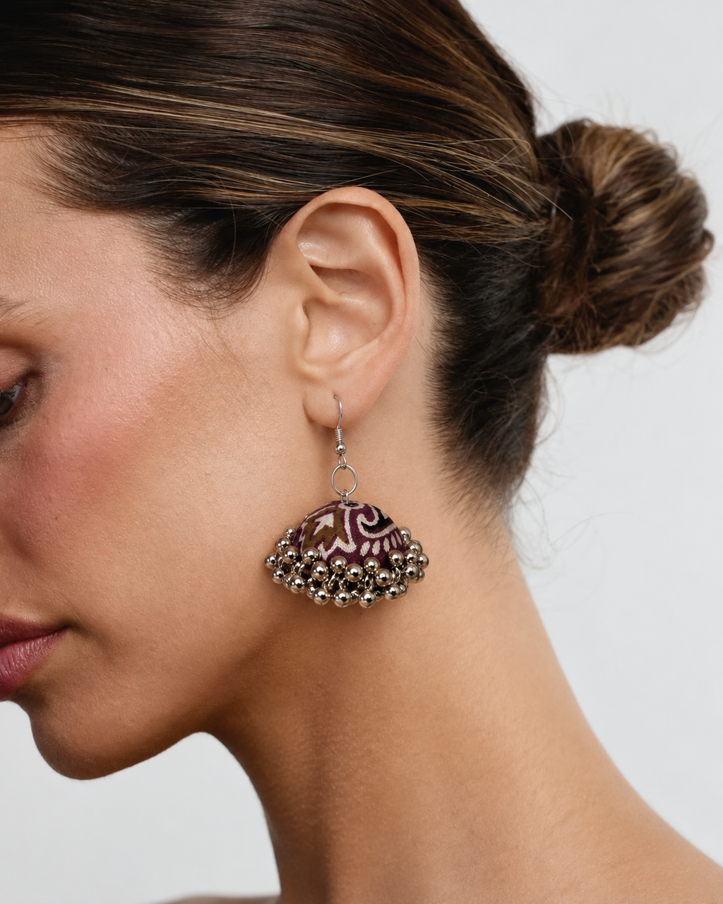 Neel Kamal jhumka worn with hair in a bun, maroon dome sitting below the ear