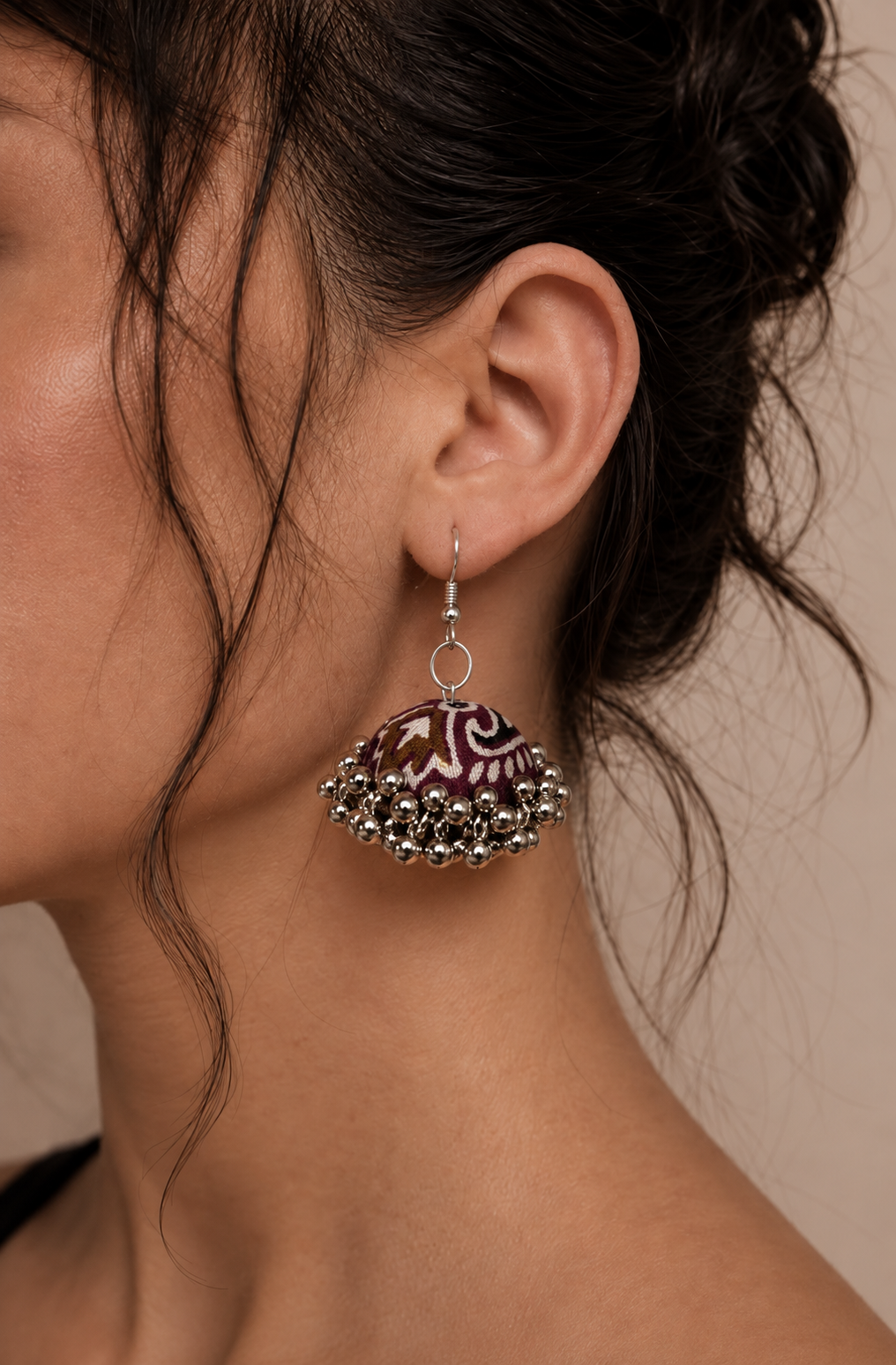 Neel Kamal jhumka against damp hair, ivory motifs clear on the maroon fabric