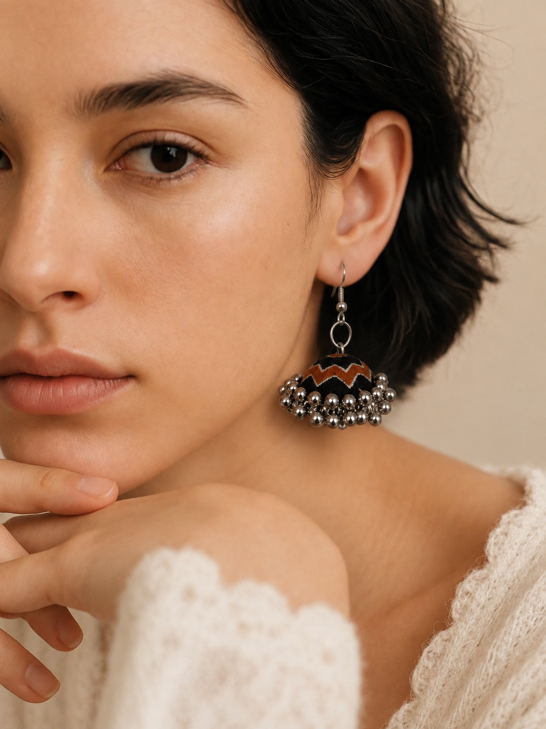 Close portrait wearing the Neel Katha jhumka, rust-orange trim visible against the dark dome