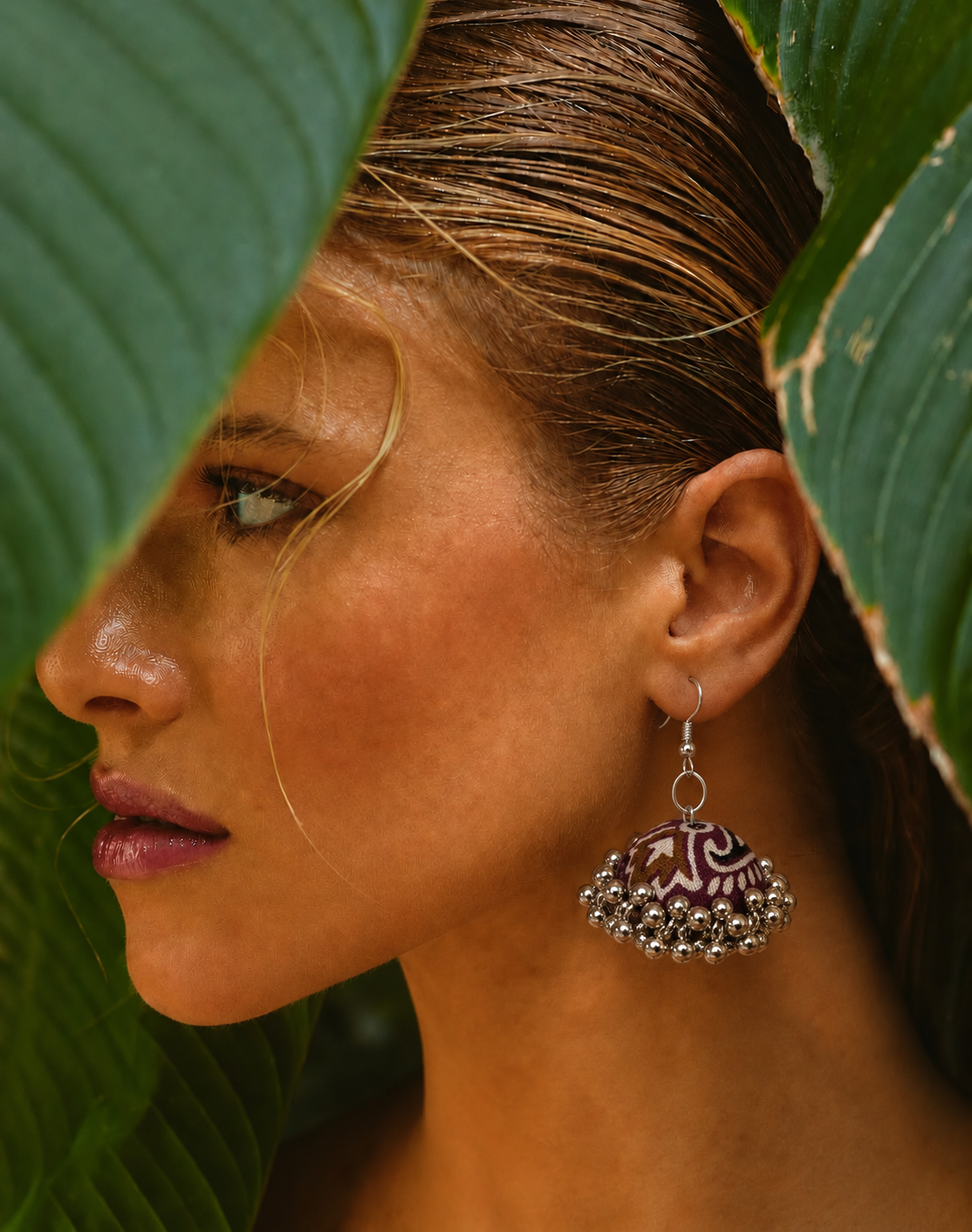 Neel Kamal jhumka in golden light with a green leaf behind