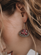 Red fabric jhumka earring with cream swirling motifs and a silver bead edge — House of Falguni