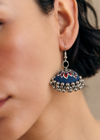Side profile with the navy and red lotus jhumka below dark hair