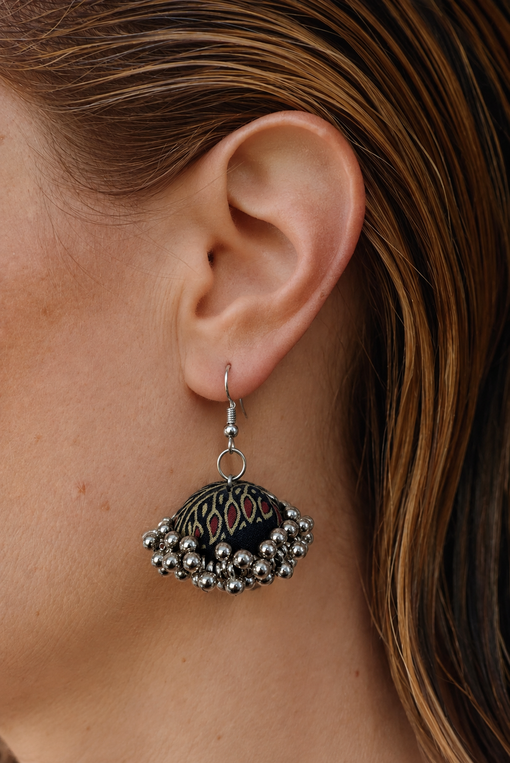Near-black fabric jhumka earring with crimson and cream flame motifs and a silver bead fringe — House of Falguni