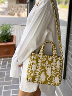 Matsya olive quilted mini tote worn on the shoulder with a white shirt