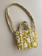 Matsya olive and white mini tote lying flat with its long matching strap