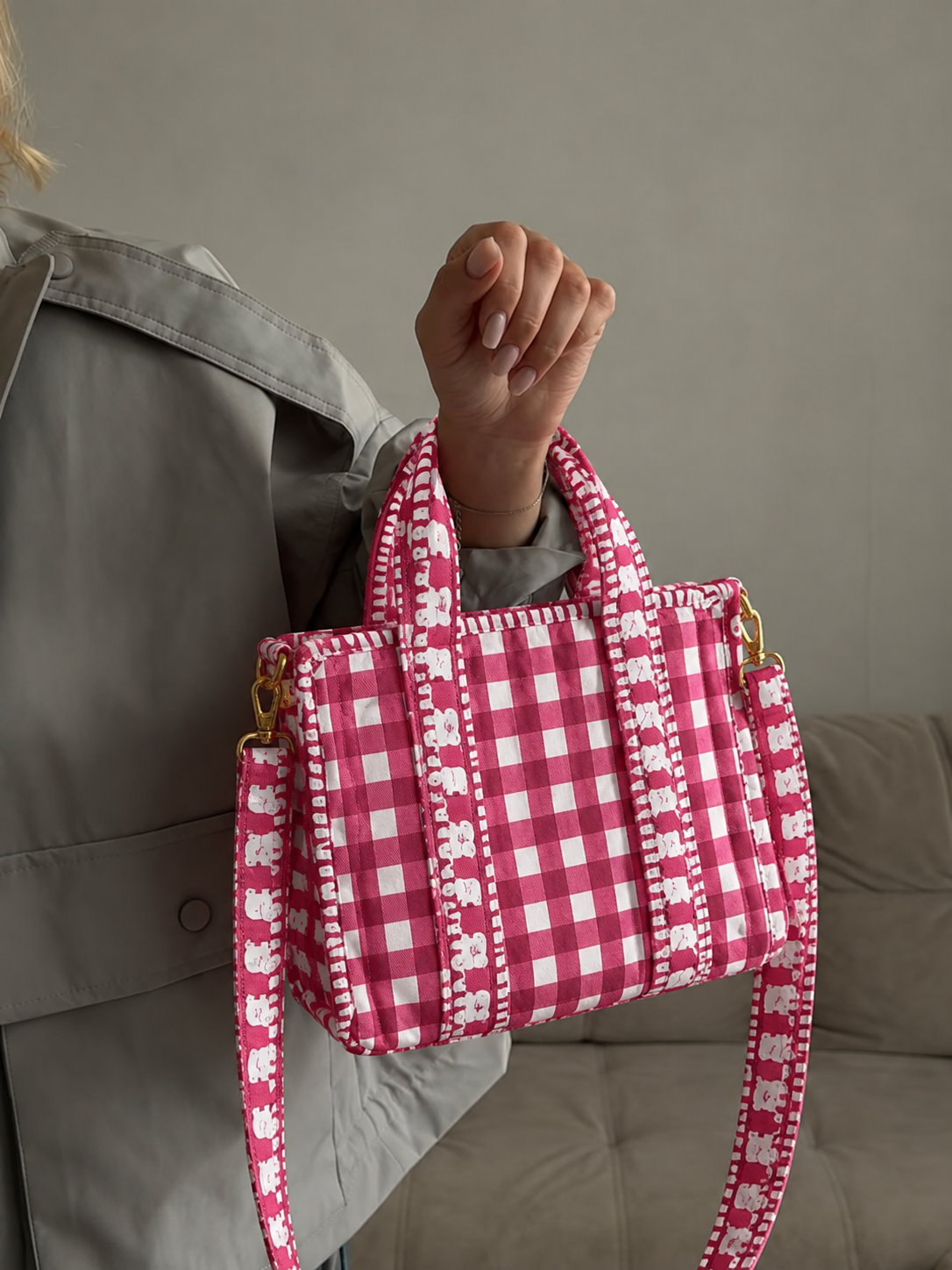 Rani pink gingham quilted mini tote held up by its top handles, with the long strap hanging below