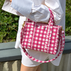 Rani pink gingham mini tote carried in the crook of the arm, with the strap looped below