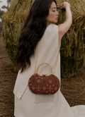 Rang Mahal red floral Ajrakh block-print Mashru silk handbag worn crossbody over an ivory dress, House of Falguni