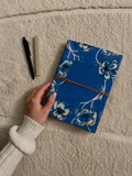 Neela Phool hand block-printed cotton fabric diary: cobalt blue with large white-outlined flowers along the edges