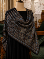 Nilufar Shahi Ajrakh black modal silk stole draped on a dress form, cream medallion and lattice print