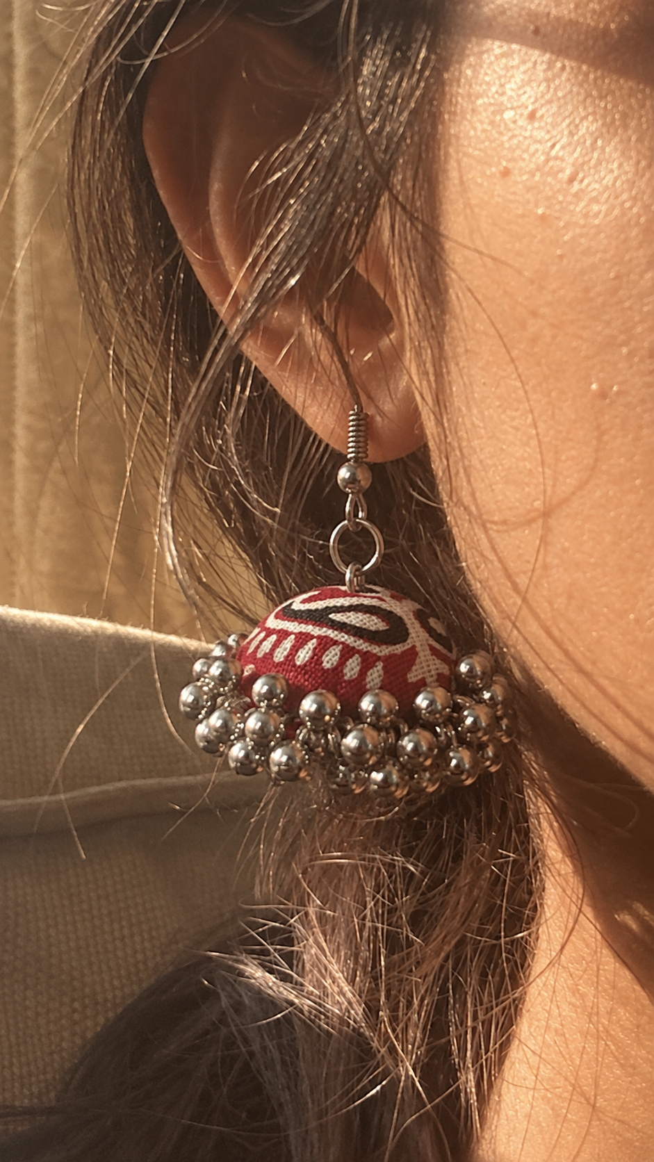 Close detail of the zigzag fabric dome and silver bead edge against a tan background