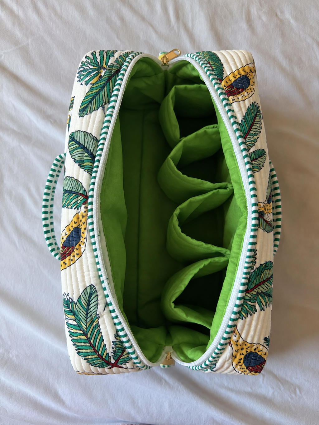 Vaan quilted hair tool bag seen from above, open to show the green lining and four vertical inner pockets