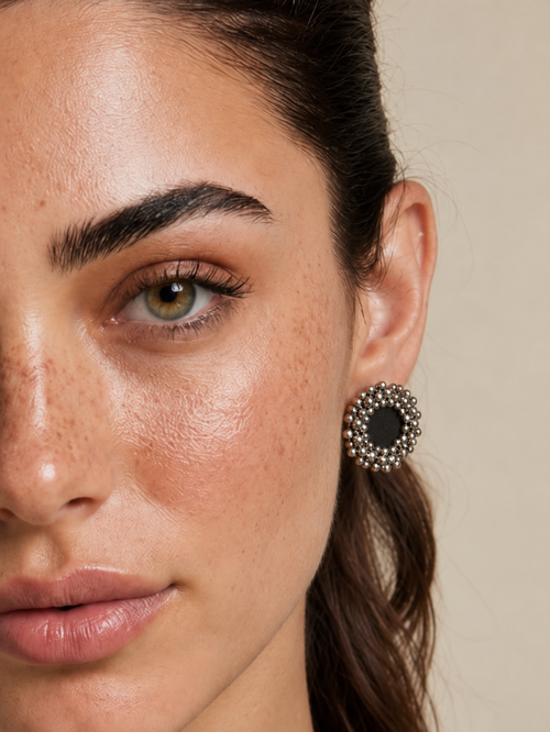 Close-up of a Charcoal Ghungroo Stud Earring on the ear: dark charcoal cotton centre ringed with silver-tone ghungroo bells