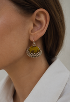 Mustard fabric jhumka earrings worn with a white collar: mustard printed dome above a silver-toned ghungroo fringe