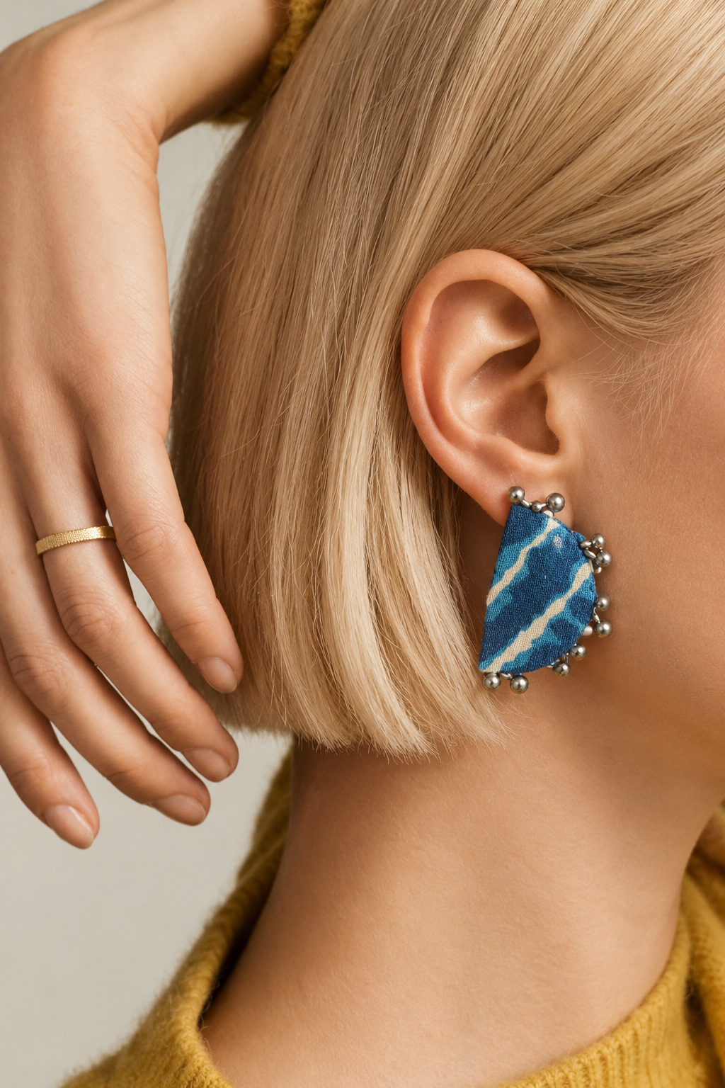 Leher Sky Blue half moon earrings worn with a mustard top: sky blue and white lehariya stripes edged with silver-tone ghungroo beads