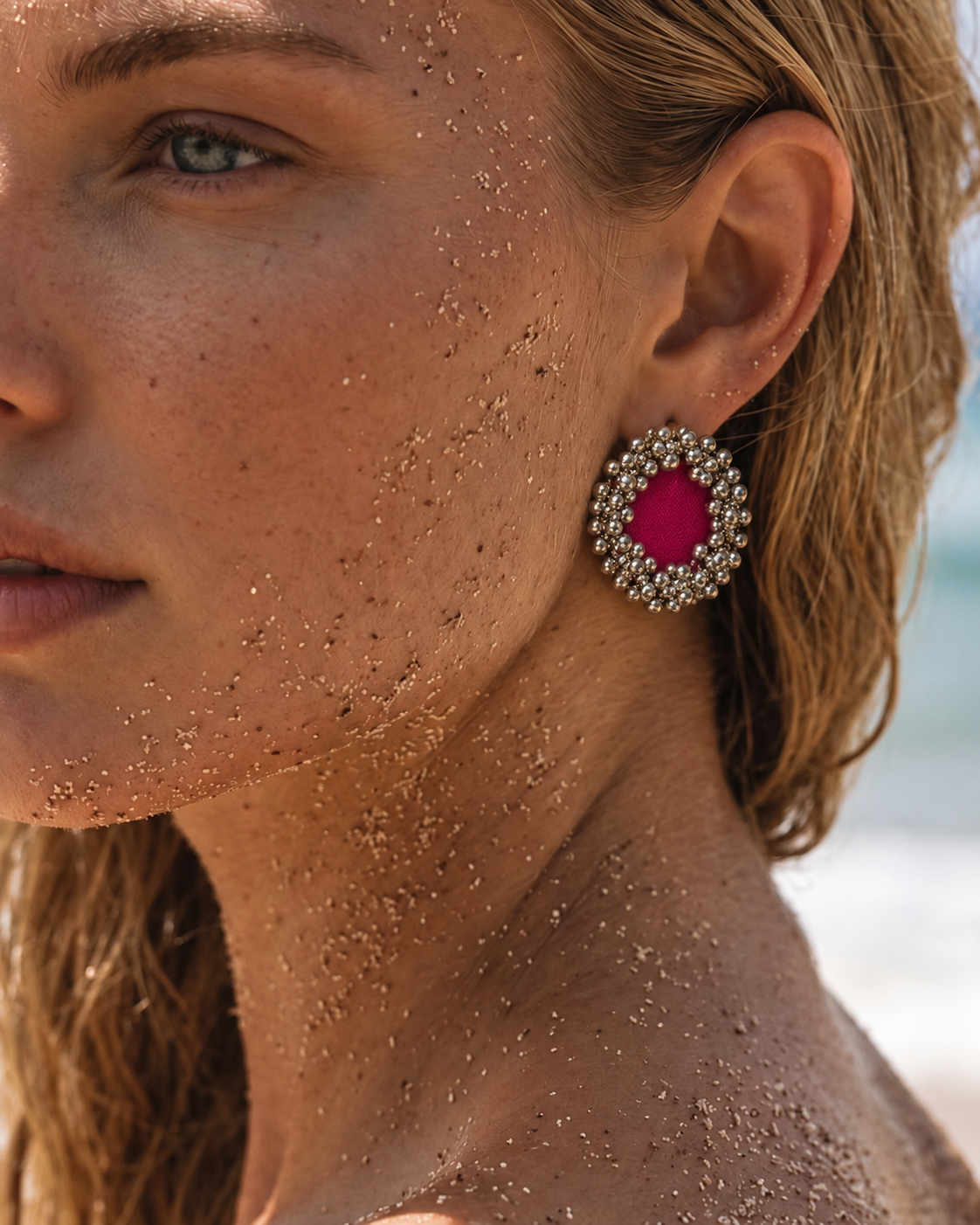 Close-up of a Fuchsia Pink Ghungroo Stud Earring on the ear: fuchsia cotton centre ringed with silver-tone ghungroo bells