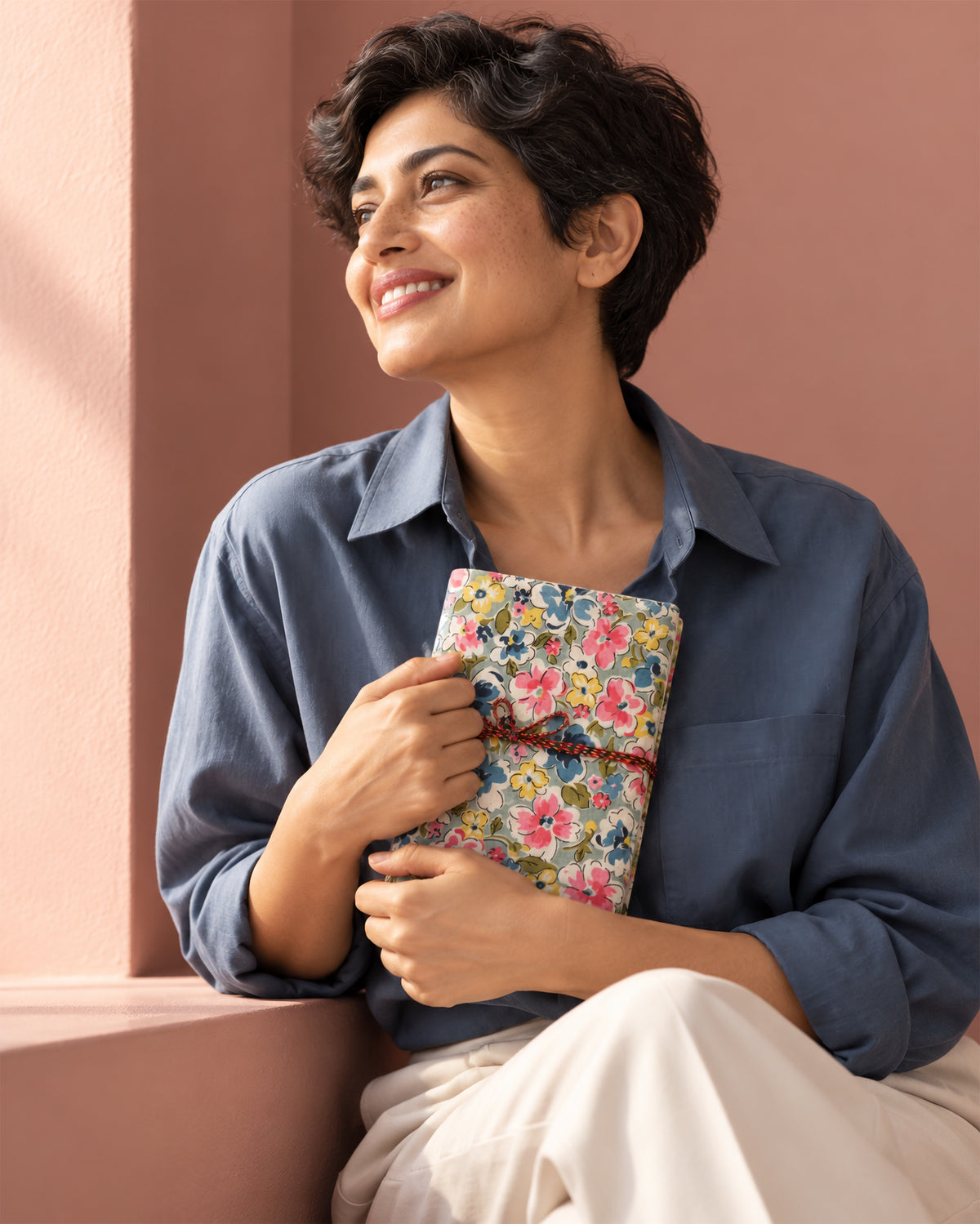 Bahar Medley Block Print Fabric Diary, 200 Unruled Pages, held in both hands, blue shirt, pink wall