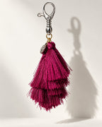 Jamuni silk tassel bag charm: one embossed silver-tone coin at the head, above tiered berry silk tassels. It hangs from a silver-tone swivel clasp.