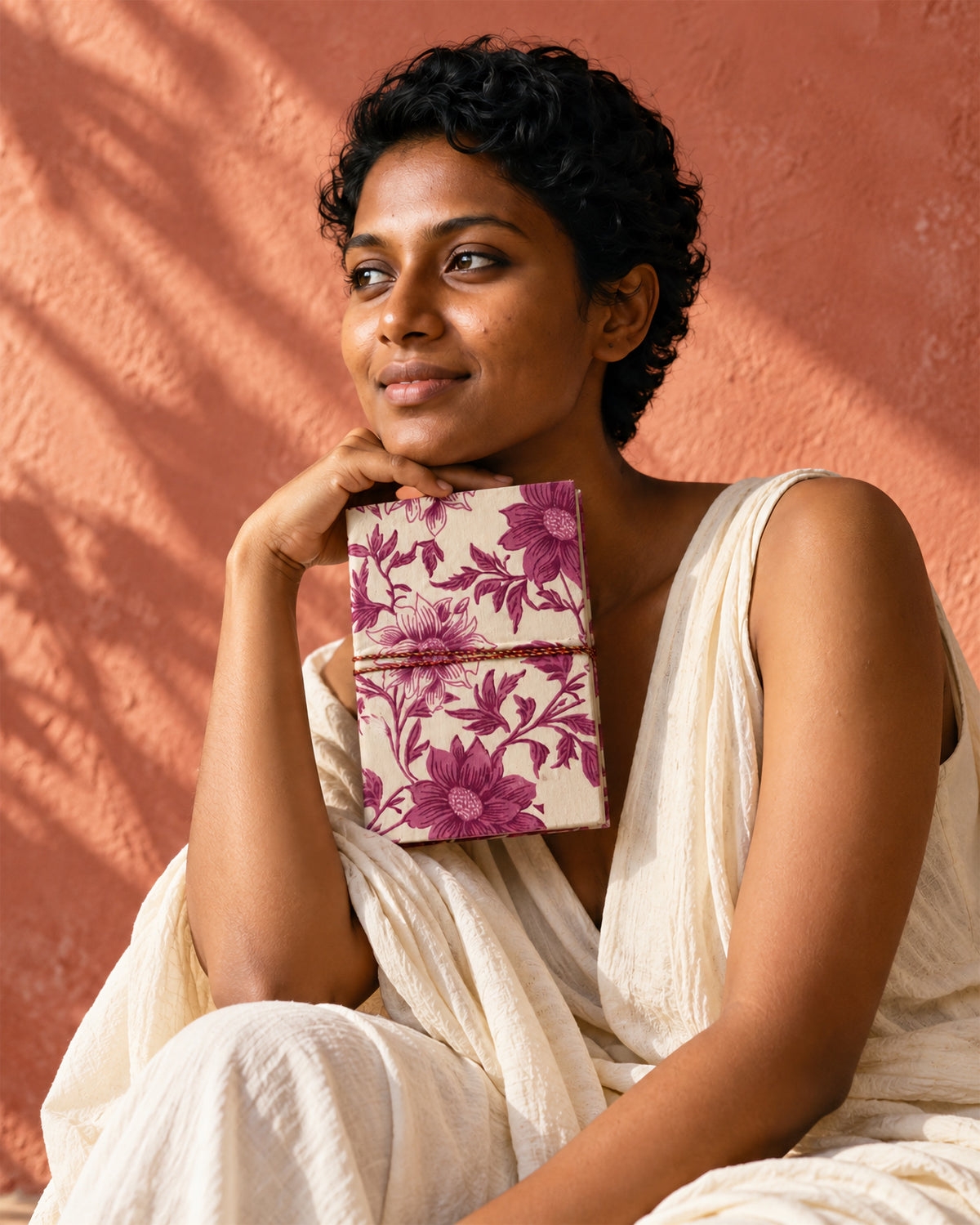 Blush Garden Block Print Fabric Diary, 200 Unruled Pages, held at the chest, white dress, terracotta wall