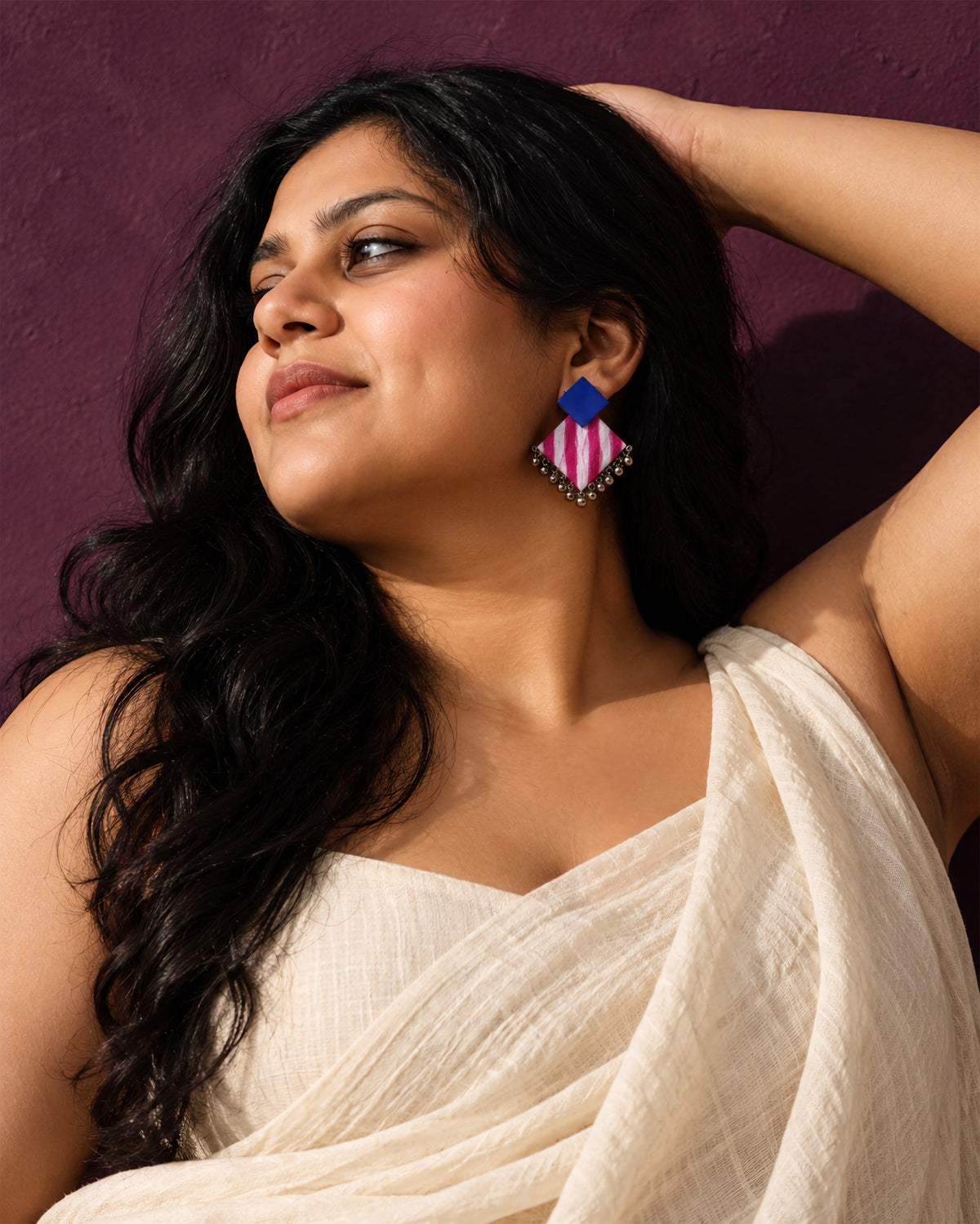 Blue & Pink Geometric Ghungroo Earrings, worn, head tilted back, aubergine wall