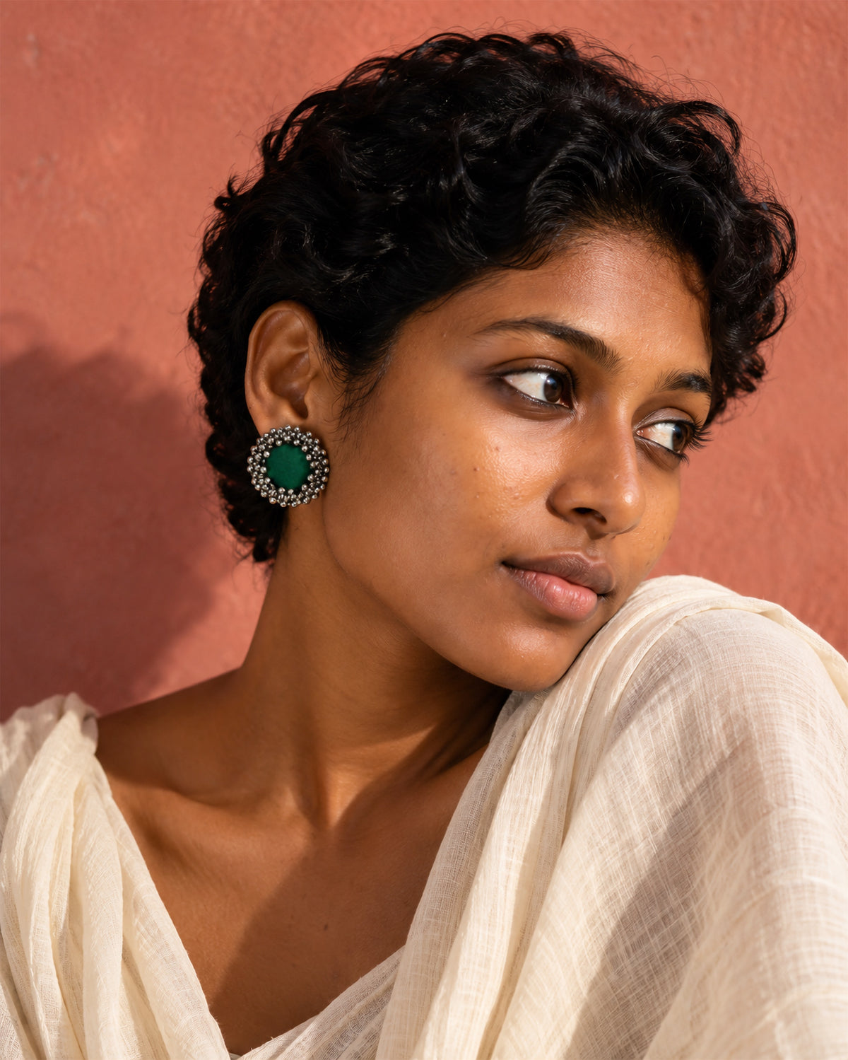 Green Ghungroo Stud Earrings, worn, cream drape, terracotta pink wall
