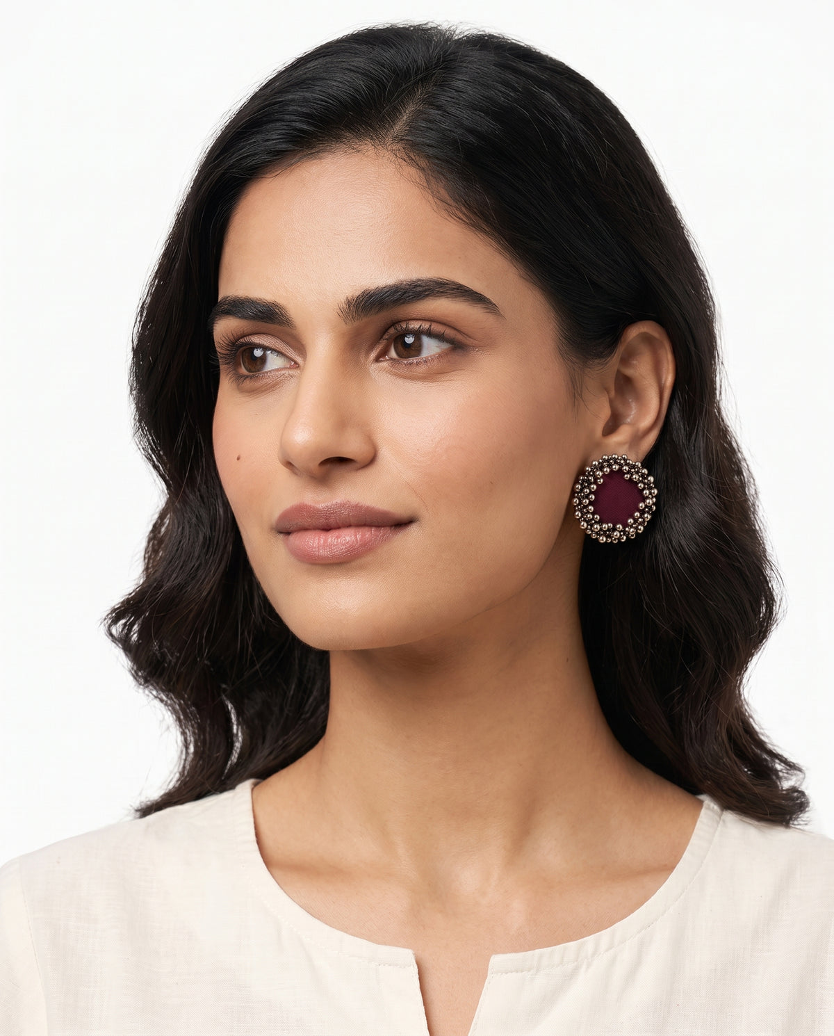 Maroon Ghungroo stud earrings styled on model (AI-generated styling image)