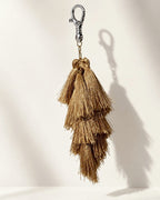 Zari silk tassel bag charm: a cluster of tiered antique-gold silk tassels on gold-tone chain links, with no ornament. It hangs from a silver-tone swivel clasp.