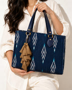Zari silk tassel charm clipped to the Midnight Ikat Laptop Tote Bag, Navy