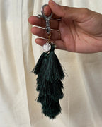 Neel Van silk tassel bag charm held in the hand to show its size, about 9 inches from clasp to fringe