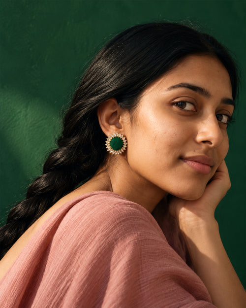 Green Floral Kundan Earrings, worn, hand at the cheek, pink top, deep emerald wall