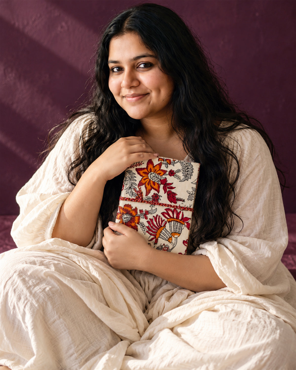 Hara Mahal Block Print Fabric Diary, 200 Unruled Pages, held at the chest, white outfit, aubergine wall