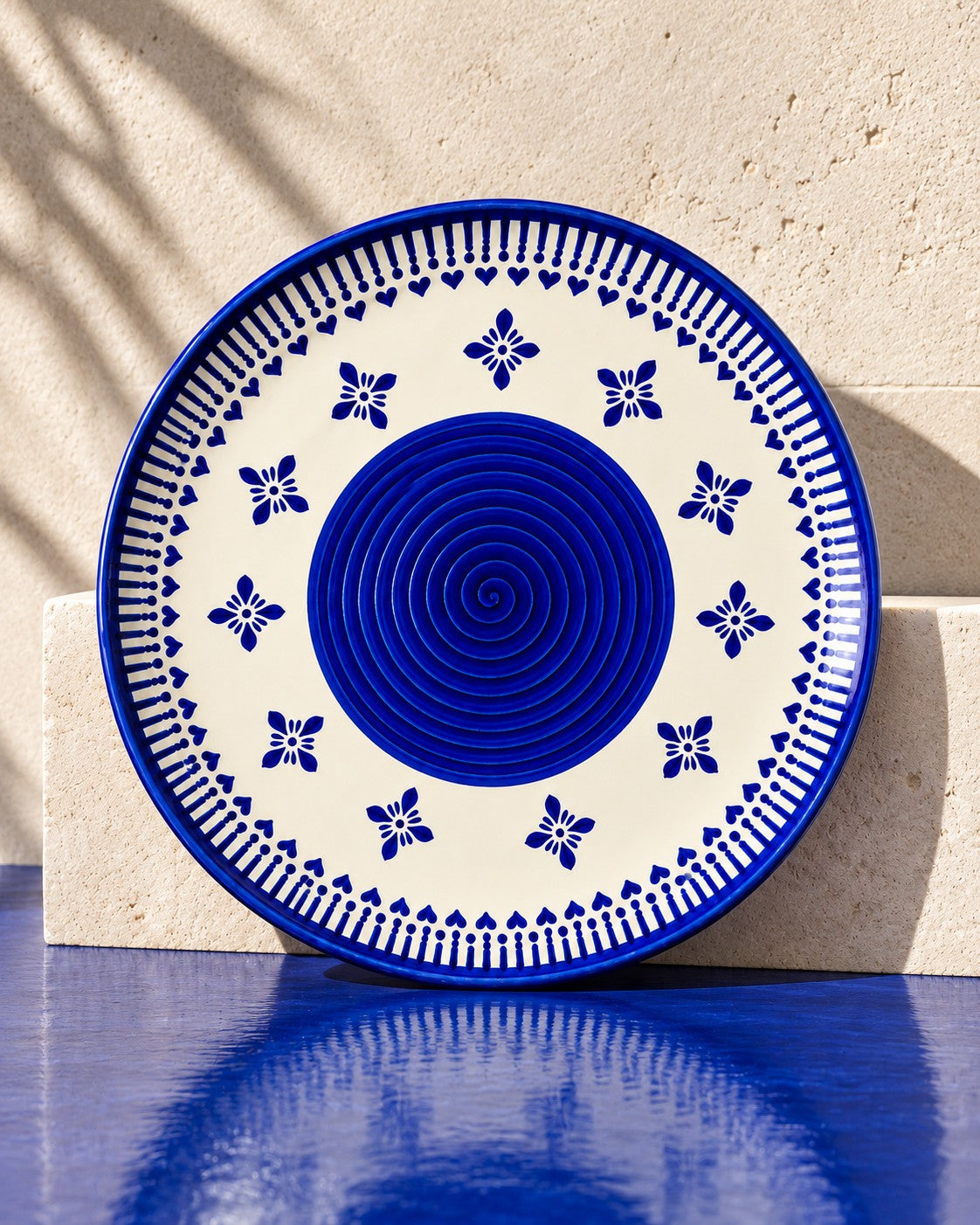Heritage Blue Ceramic Quarter Plates (Set of 2) one plate standing on a steel ledge with its reflection